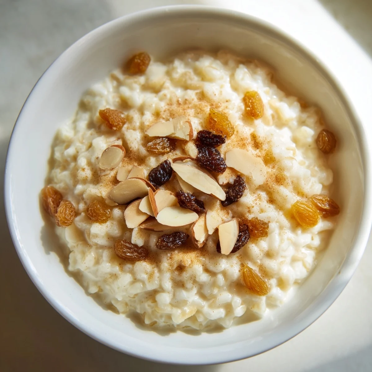 A spoon digging into cozy Chai Spiced Rice Pudding reveals a thick, creamy texture scented with cardamom and ginger.