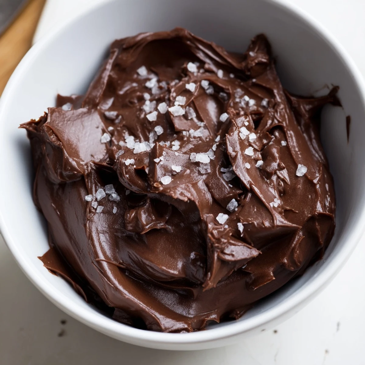 Smooth chocolate ganache drizzled over a slice of moist cake, ready to serve warm.