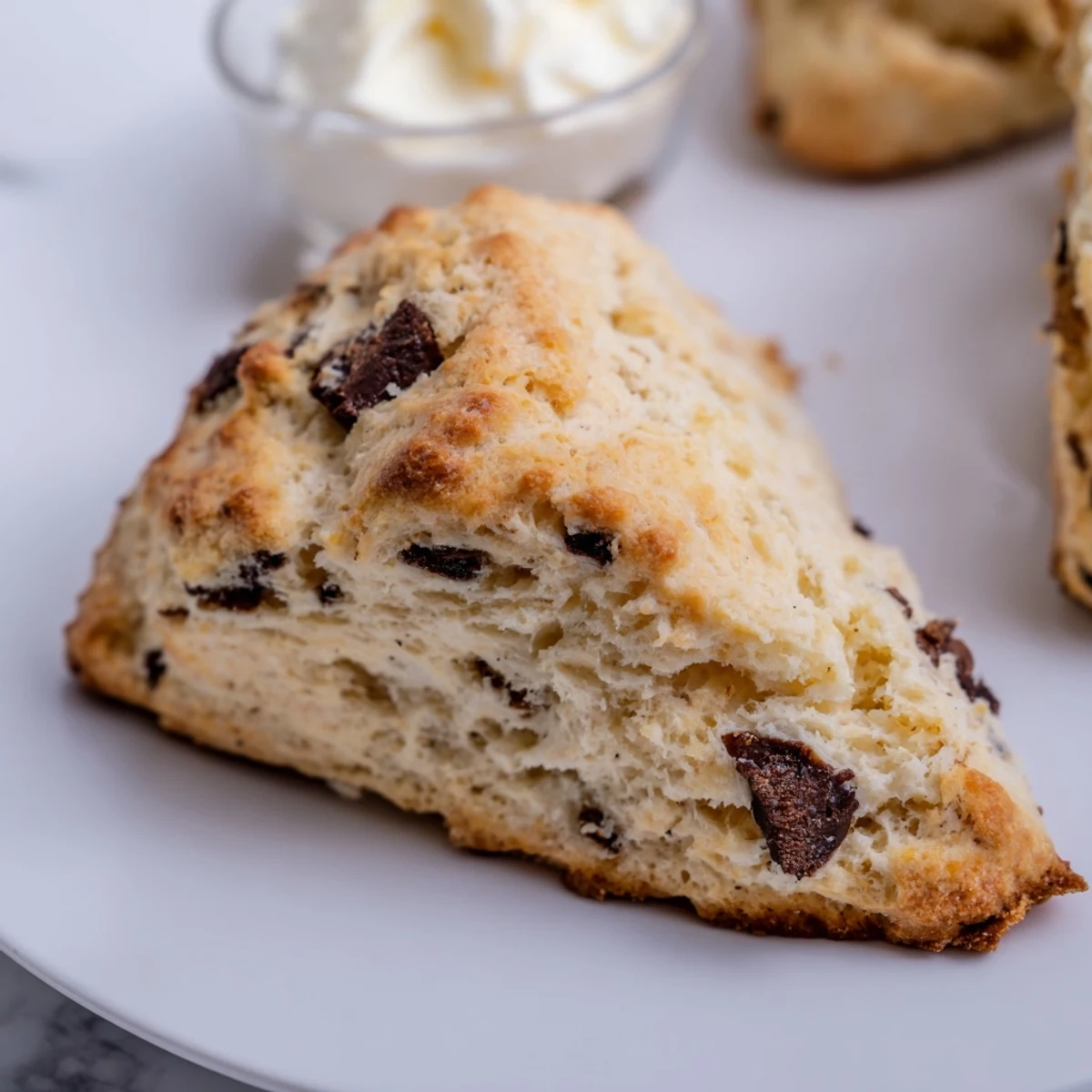 Golden-brown chocolate chip scones cooling on a wire rack, perfect for a cozy breakfast or afternoon tea.  