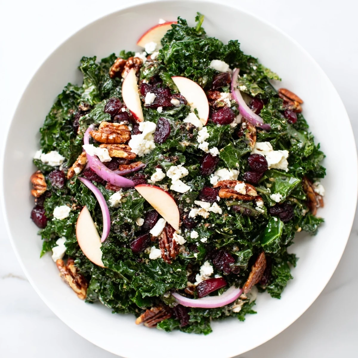 A vibrant Winter Kale Salad with Pecans and Cranberries glistens with maple-Dijon vinaigrette, showcasing massaged kale leaves, toasted nuts, and tart dried fruit.  