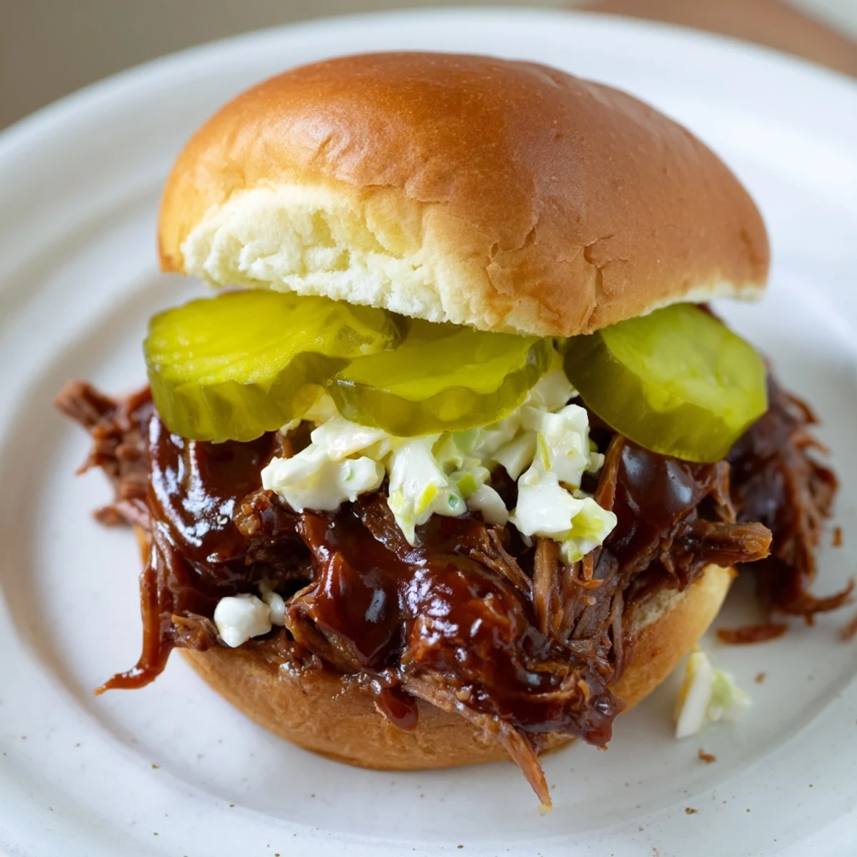 Golden-brown, slow-cooked beef brisket piled high on toasted slider buns, glistening with homemade tangy BBQ sauce and topped with crisp coleslaw.