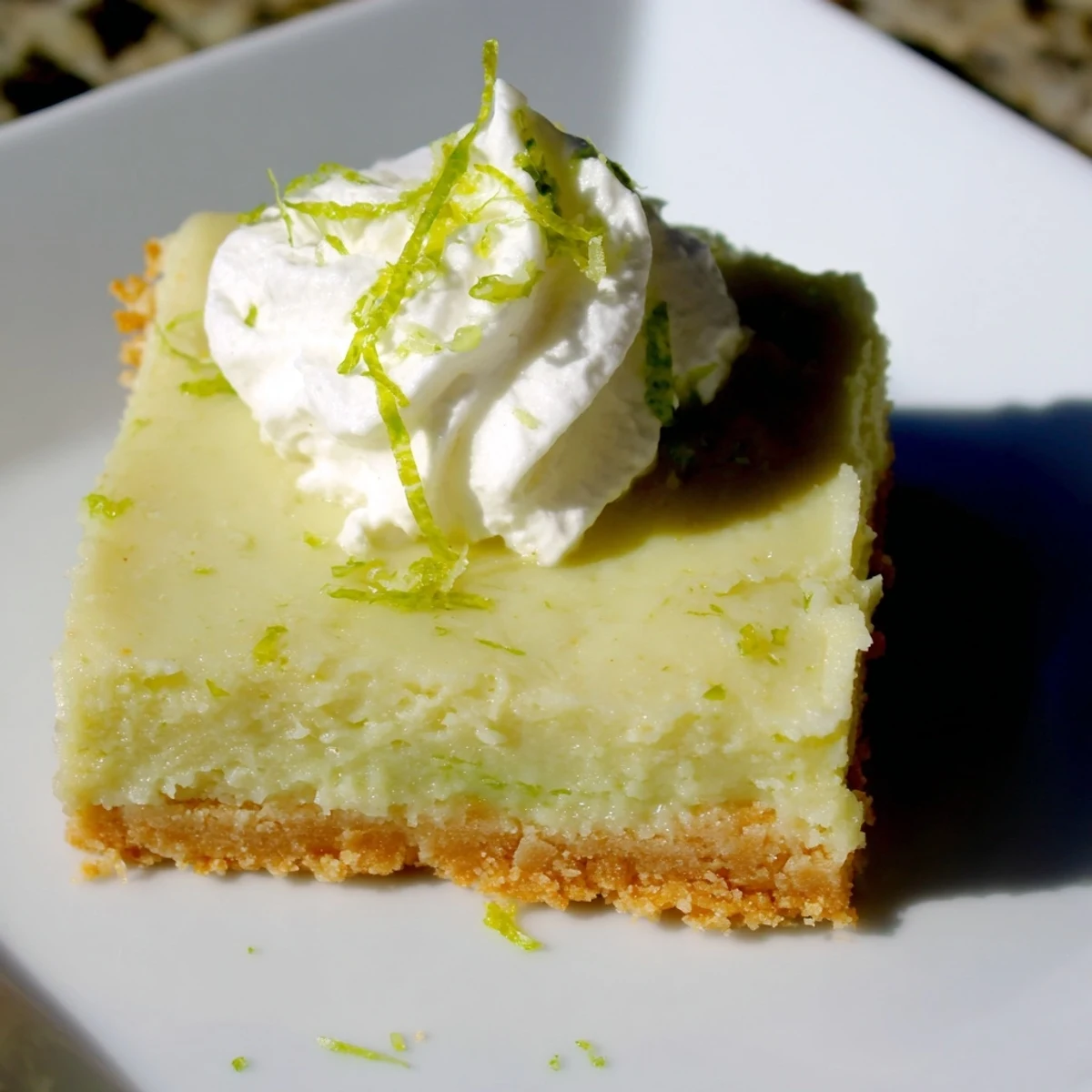 A close-up of creamy Key Lime Pie Bars, revealing their tangy, pale green filling and crunchy buttery graham cracker crumb base.  