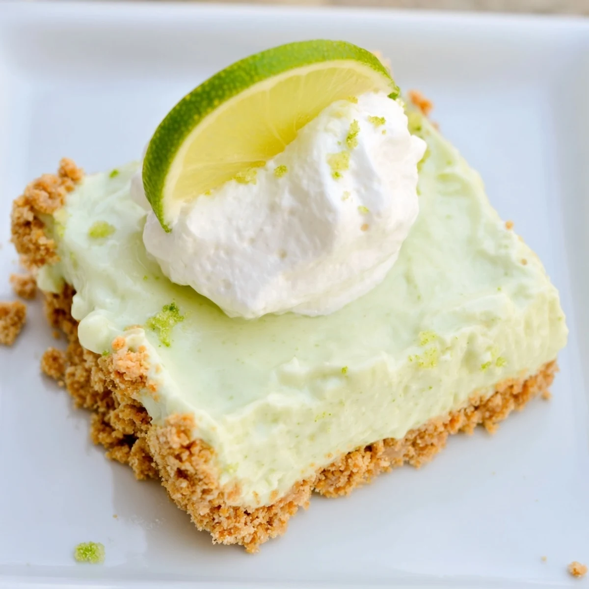 Freshly baked Key Lime Pie Bars cool on a wire rack, showcasing their golden graham cracker crust and vibrant green filling.