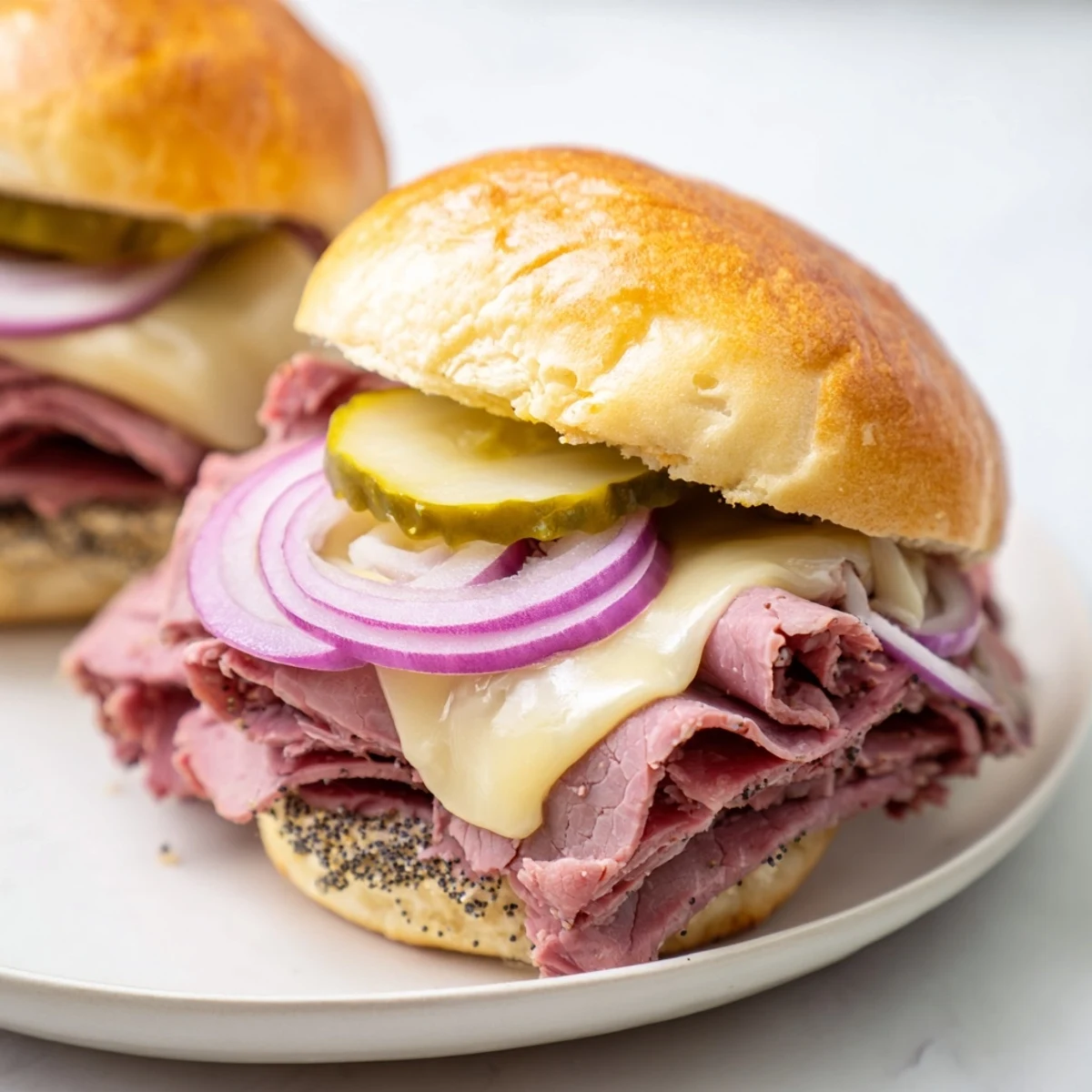 Golden, melted Swiss cheese and tender corned beef peek from soft, buttery slider buns, brushed with a savory mustard glaze.