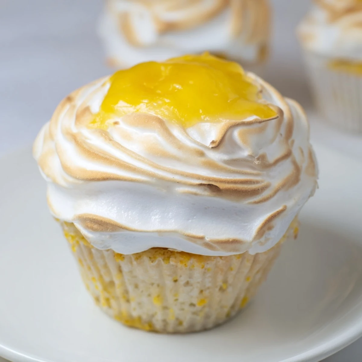Freshly baked Lemon Meringue Cupcakes with golden toasted meringue swirls and bright lemon zest ready to serve.