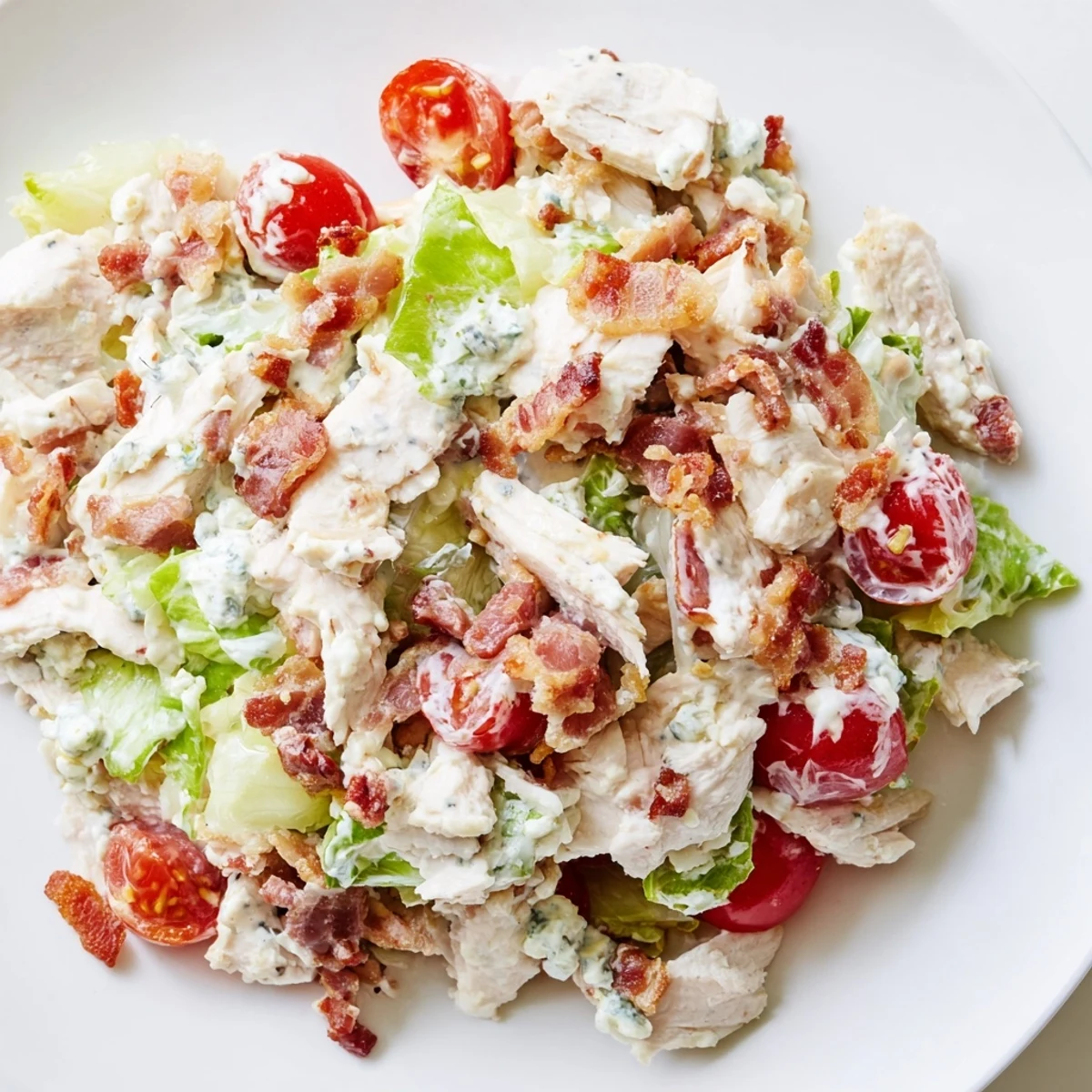 A vibrant bowl of BLT Chicken Salad tossed with cherry tomatoes and romaine, perfect for a summer gathering.