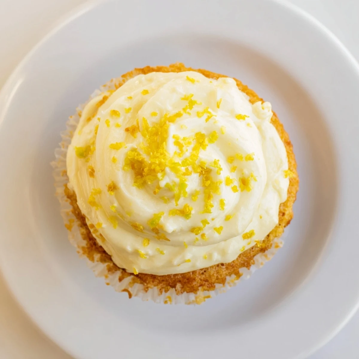 Light, zesty Limoncello cupcakes topped with buttery frosting and lemon zest are ready for spring gatherings on a marble board.