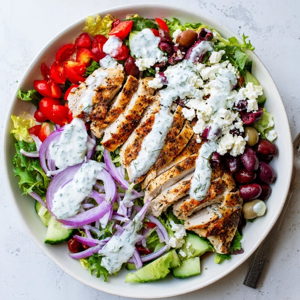 Fresh chopped vegetables and crumbled feta cheese are tossed with juicy grilled chicken in this Tzatziki Chicken Salad.