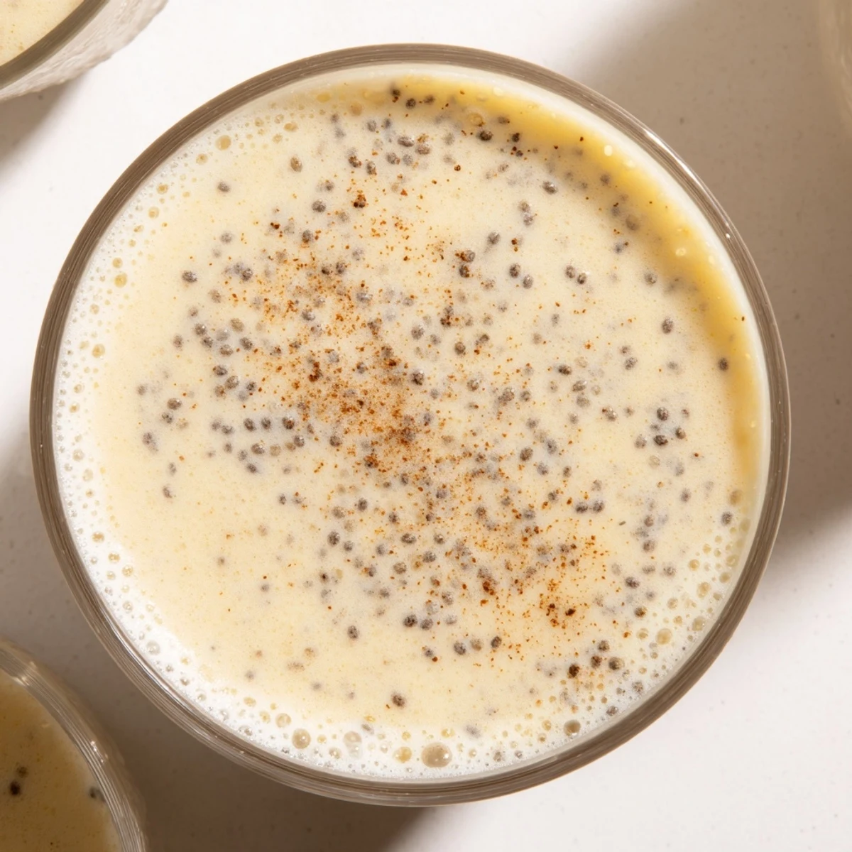 Creamy Greek yogurt banana smoothie poured into a tall glass with fresh banana slices on the rim