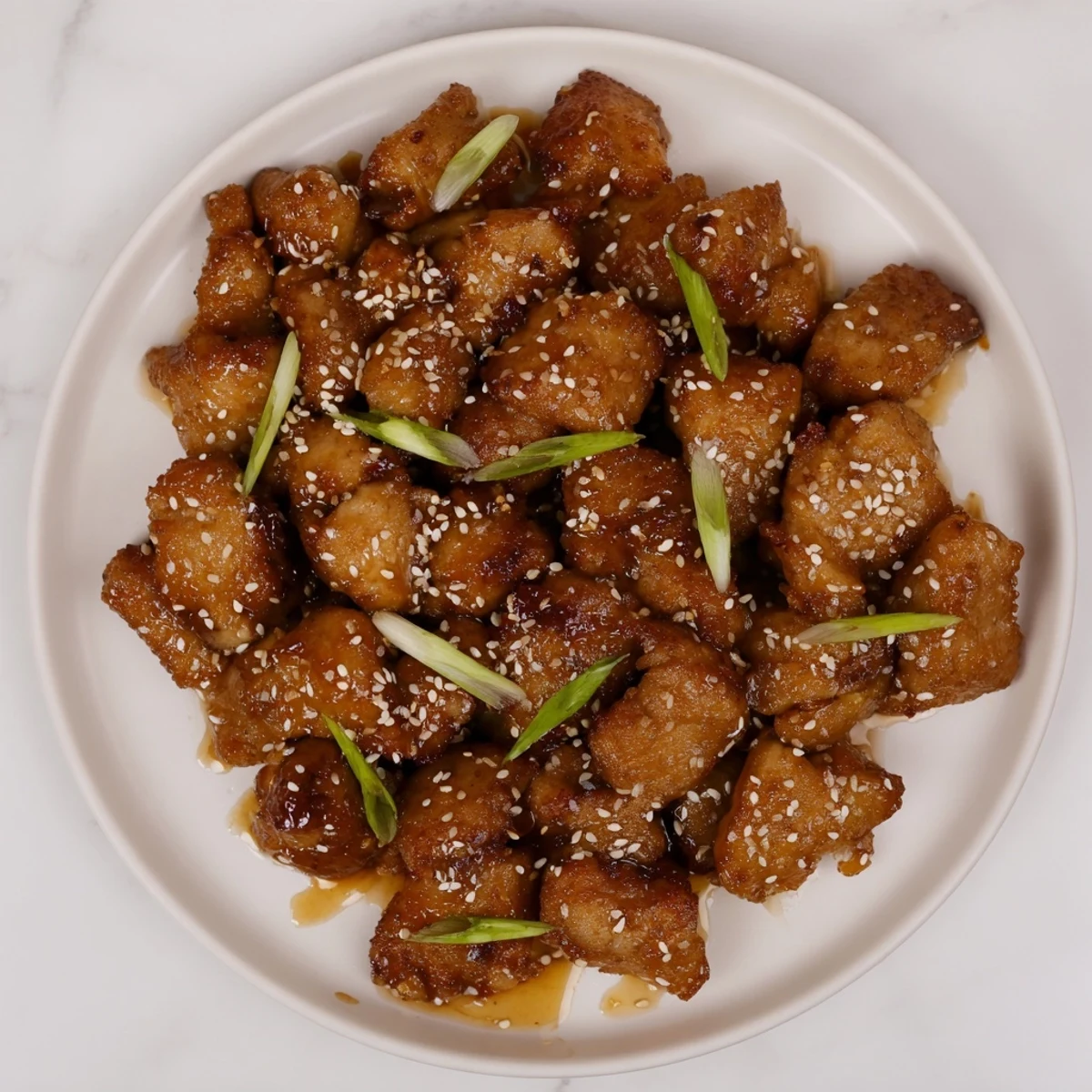Crispy Mongolian chicken served over white rice with green onions and toasted sesame seeds