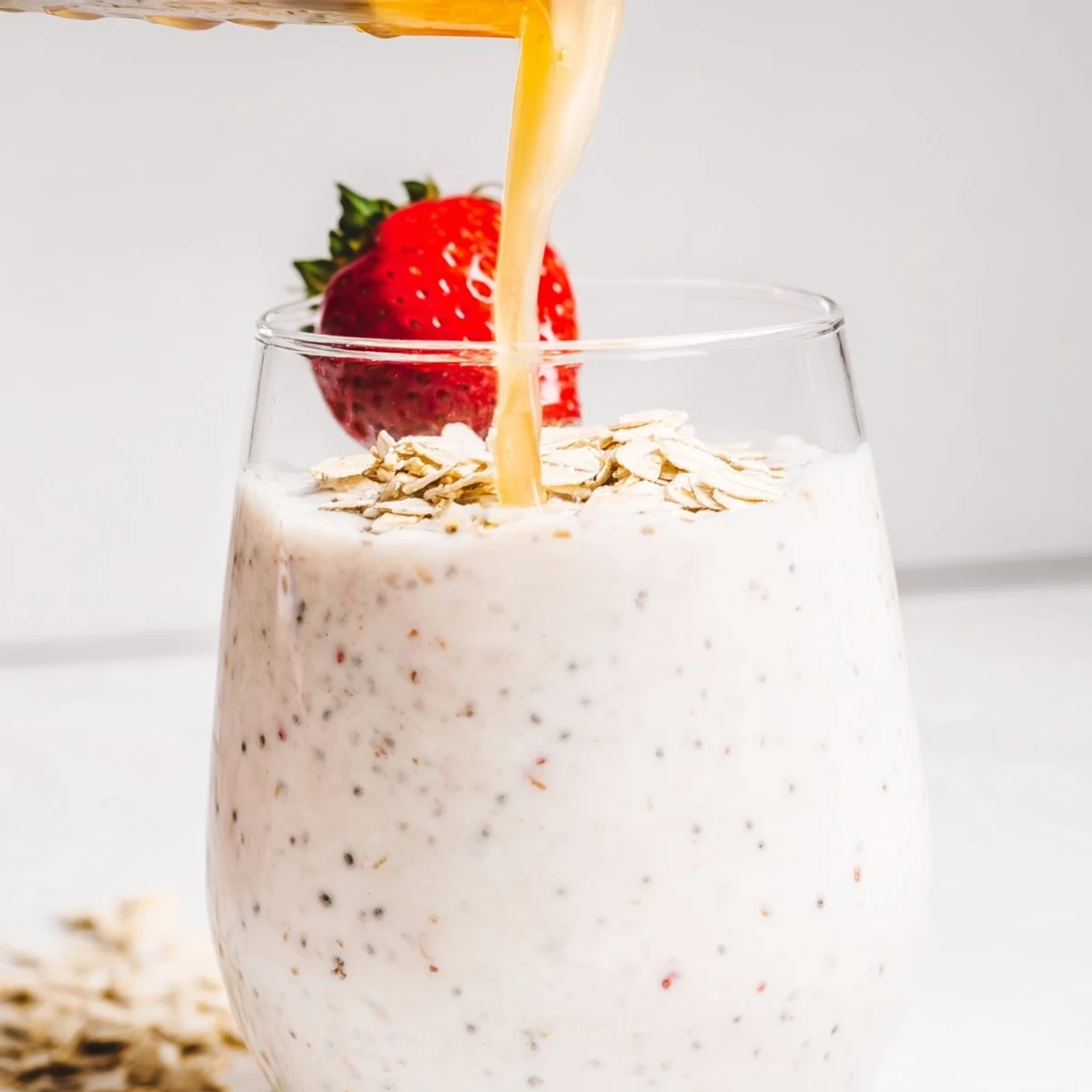 Protein-packed Greek yogurt breakfast smoothie poured into two glasses with whole strawberry garnish