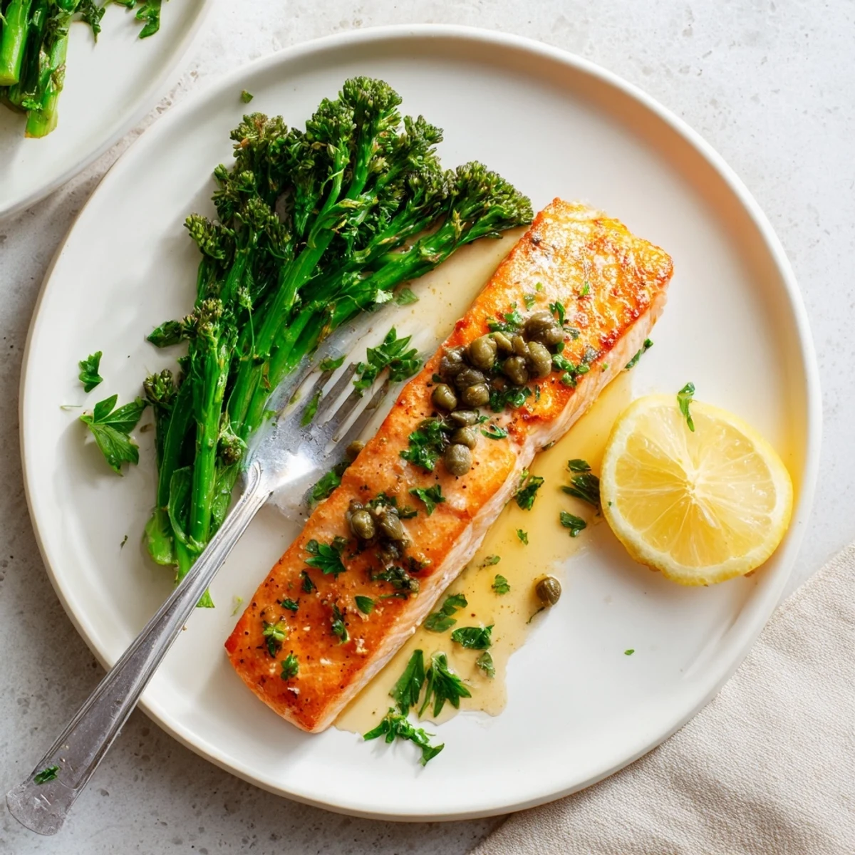 Crispy-skinned Gordon Ramsay pan fried salmon served with tender broccoli and lemon wedges