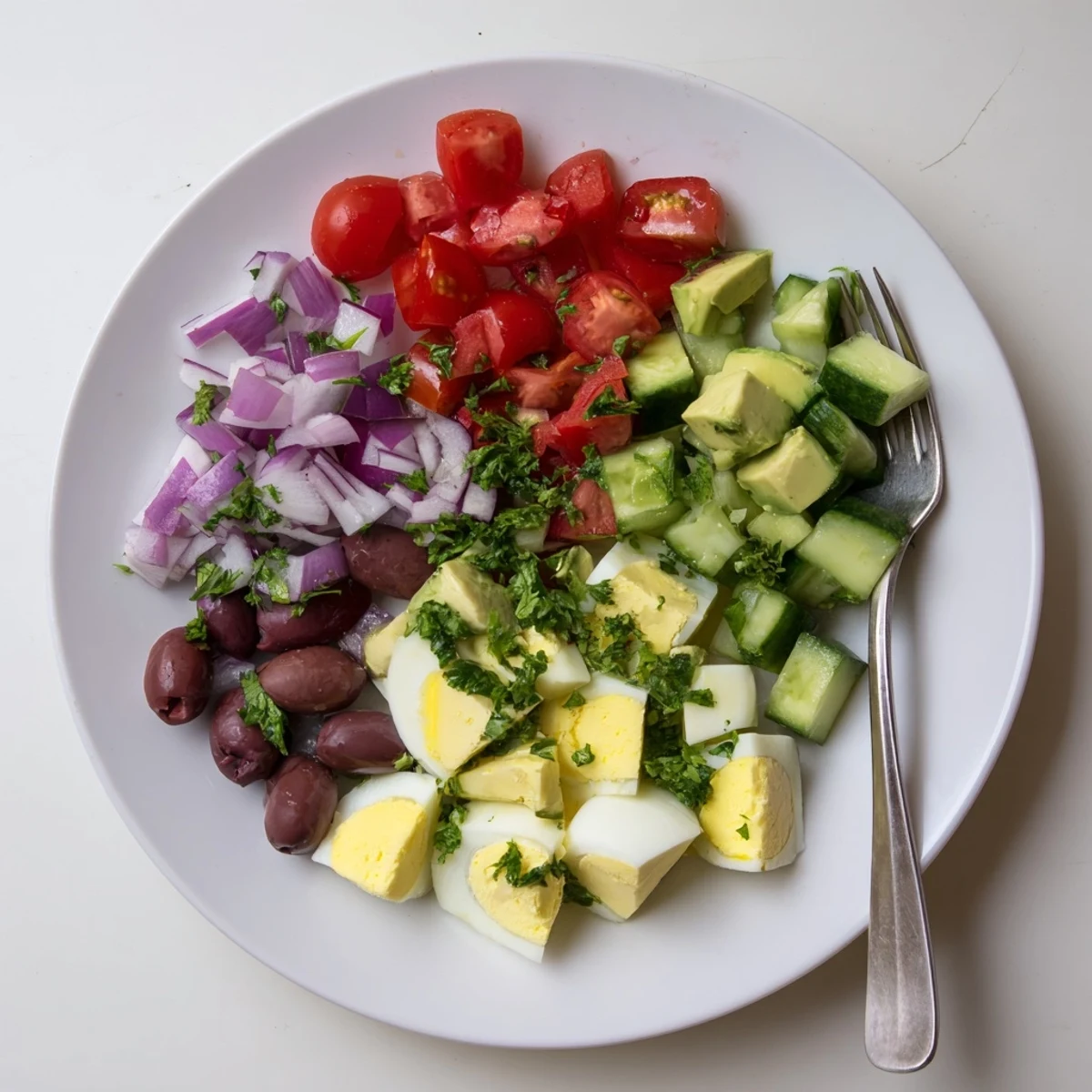 Light and refreshing Mediterranean avocado egg salad plated with crisp cucumber and red onion