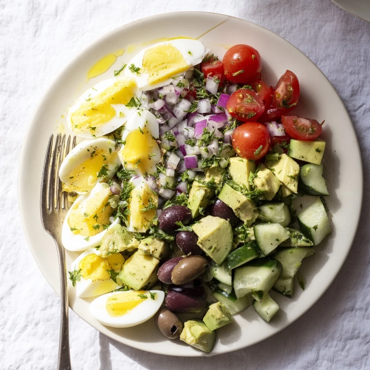 Vibrant zesty Mediterranean avocado egg salad featuring chunky avocado, cherry tomatoes, and kalamata olives