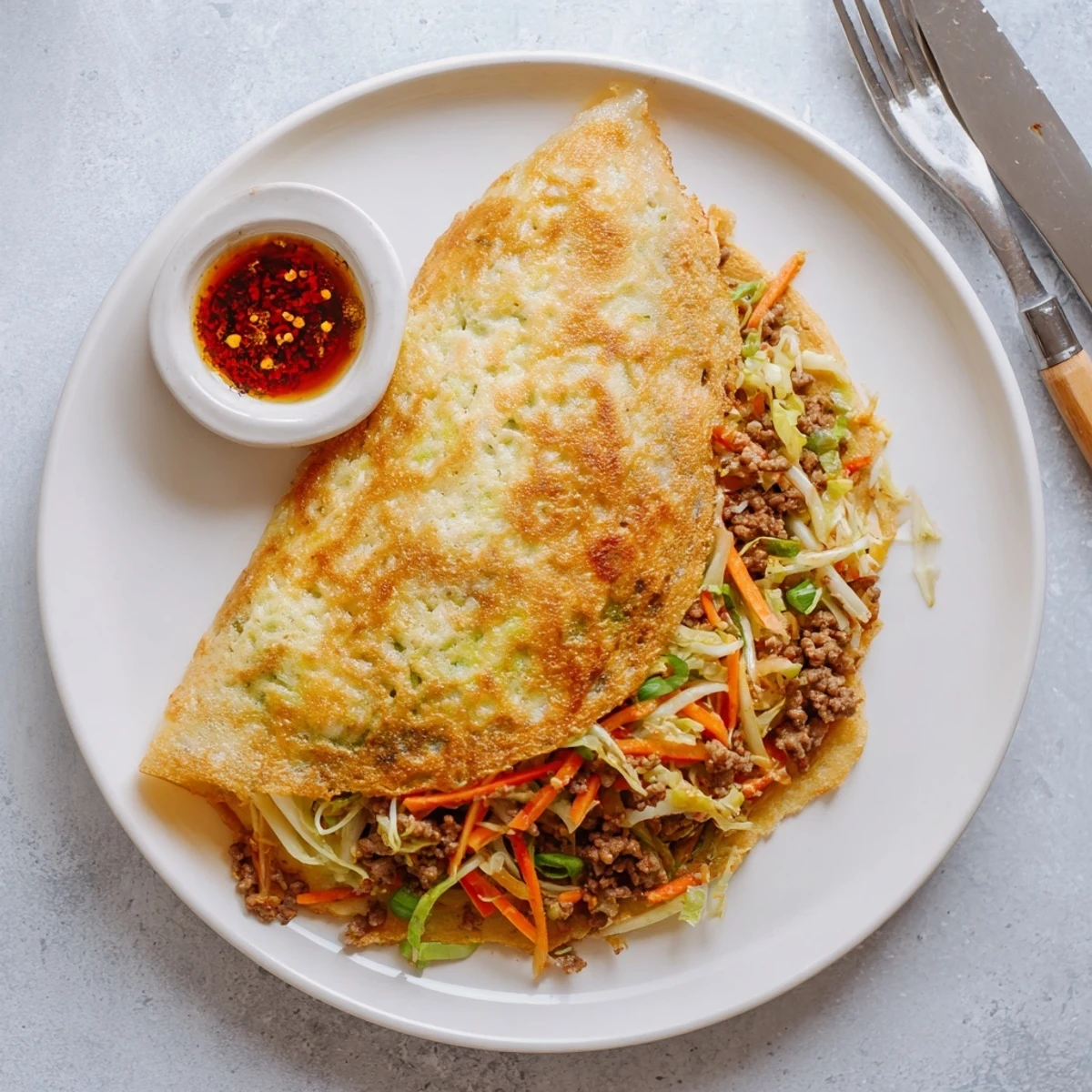 Fluffy breakfast pancakes folded over egg and vegetable filling in a folded half-moon shape
