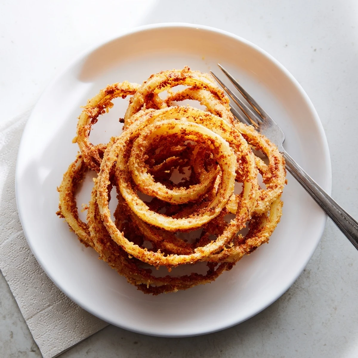 Ultra-thin fried onion ring chips stacked high showing their crunchy golden brown texture