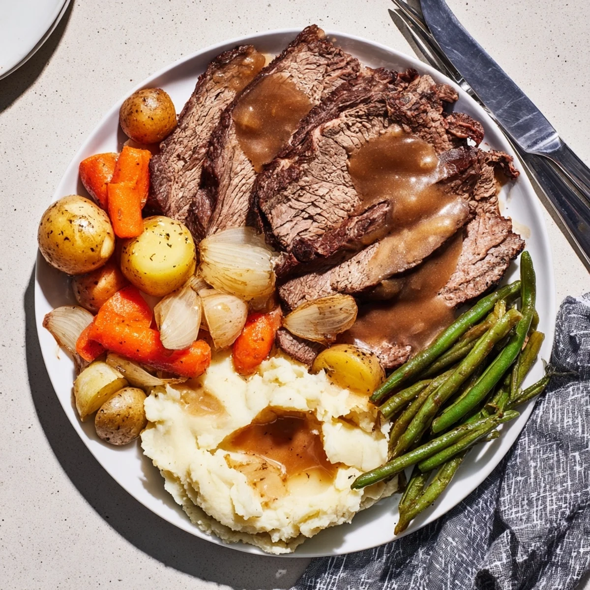 Slow-cooked Southern style pot roast plate featuring fork-tender beef nestled with carrots and onions in savory broth