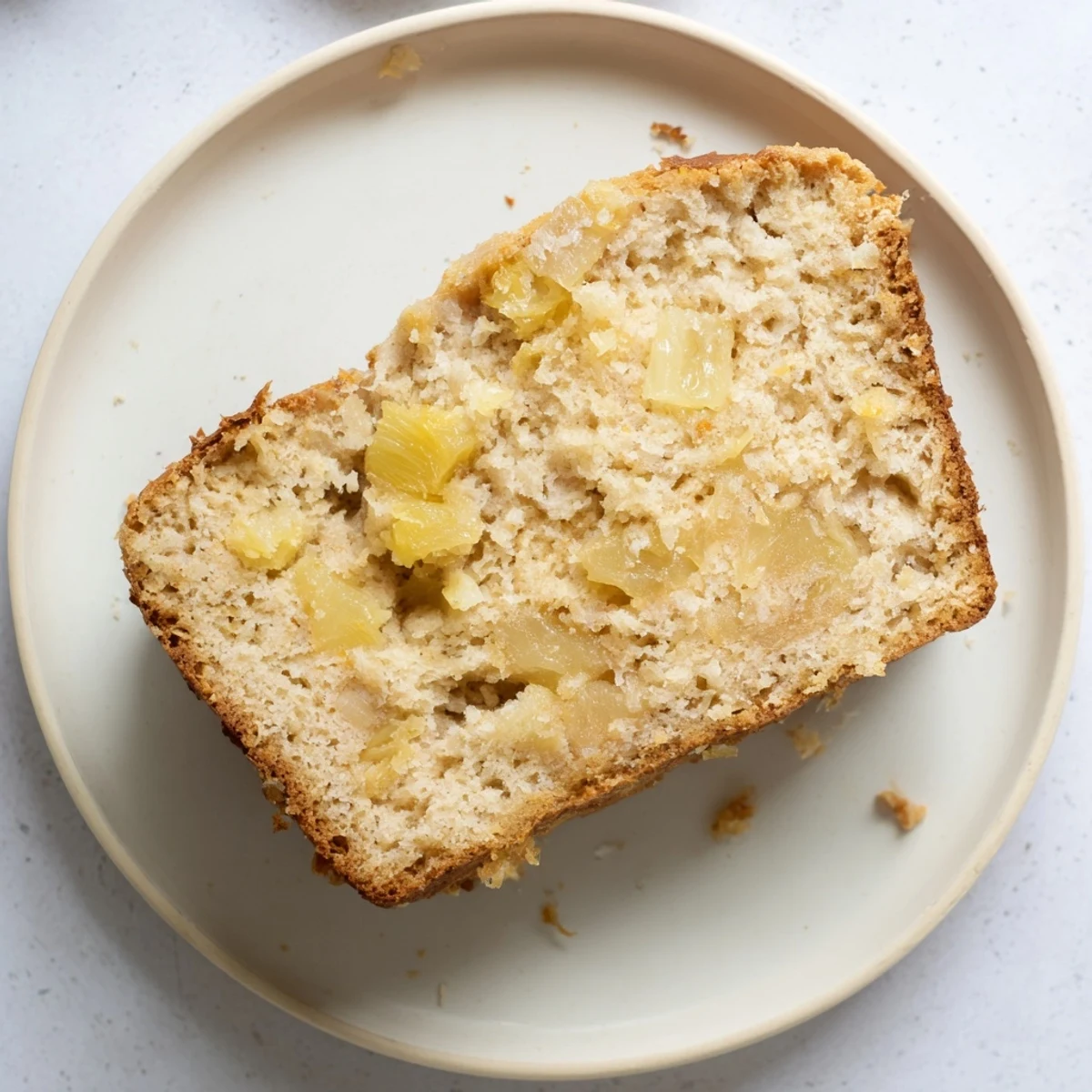 Freshly baked cozy pineapple coconut bread cooling on a wire rack with a golden crust