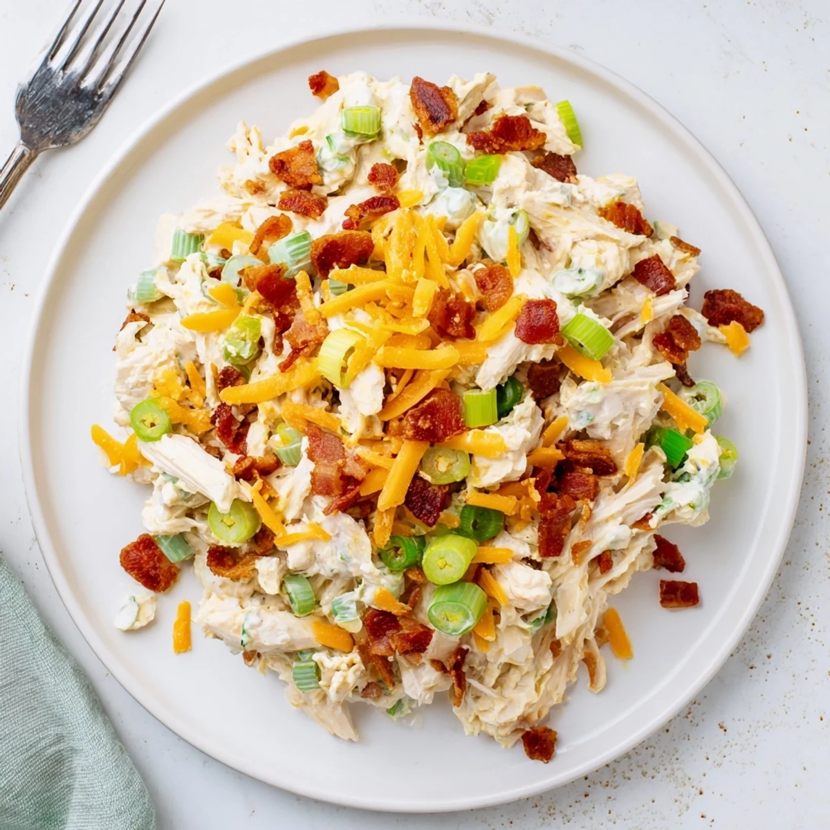 Creamy keto chicken salad loaded with bacon, jalapenos, and cheddar in a white bowl