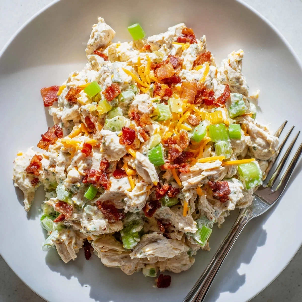 Savory jalapeno popper chicken salad served chilled with crisp celery sticks and green onions