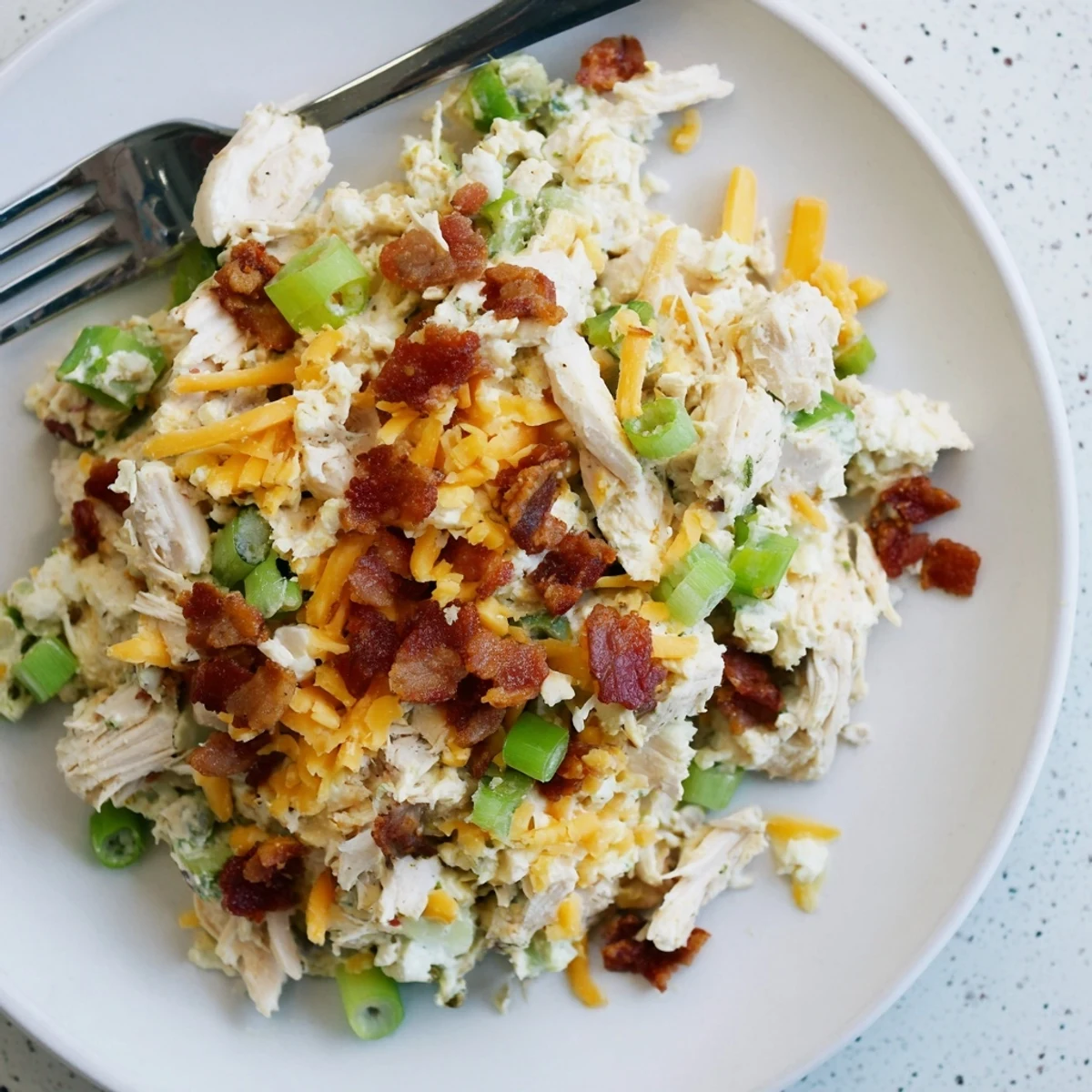 Low-carb chicken salad featuring spicy jalapenos, crispy bacon, and shredded cheddar cheese