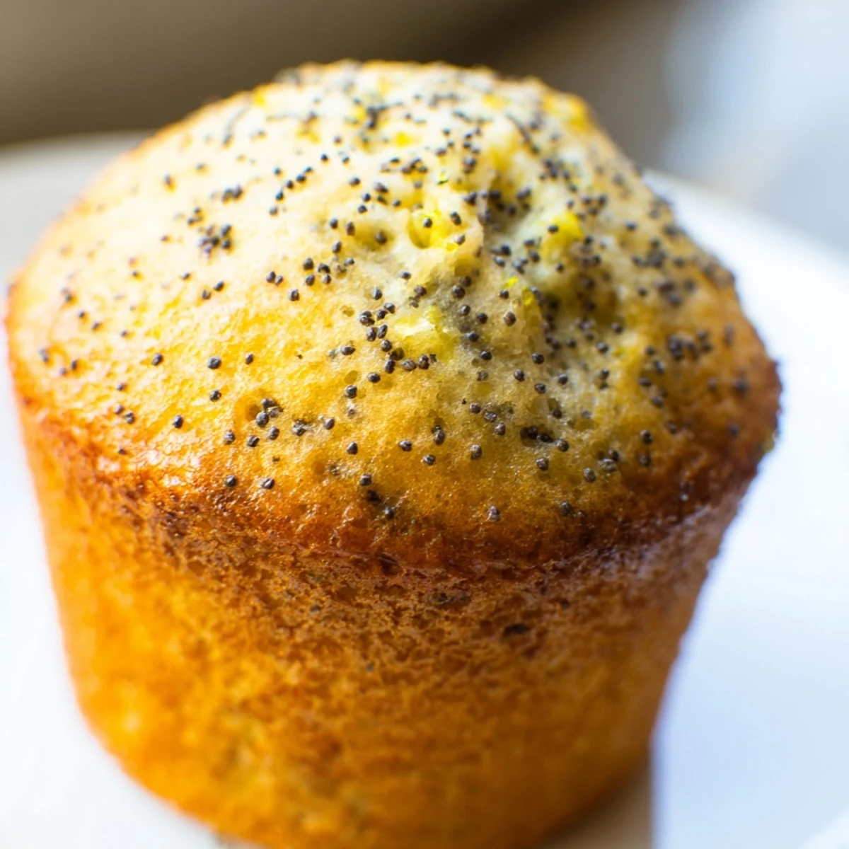 Golden lemon poppy seed muffins with domed tops fresh from the oven ready to serve