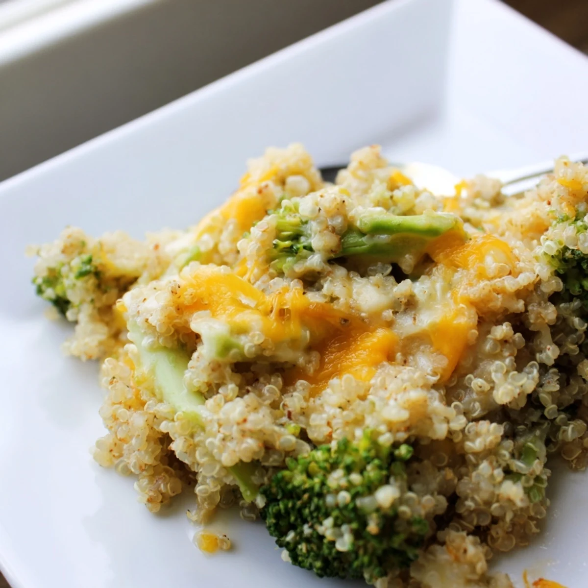 Golden bubbly creamy broccoli quinoa casserole fresh from the oven in a baking dish