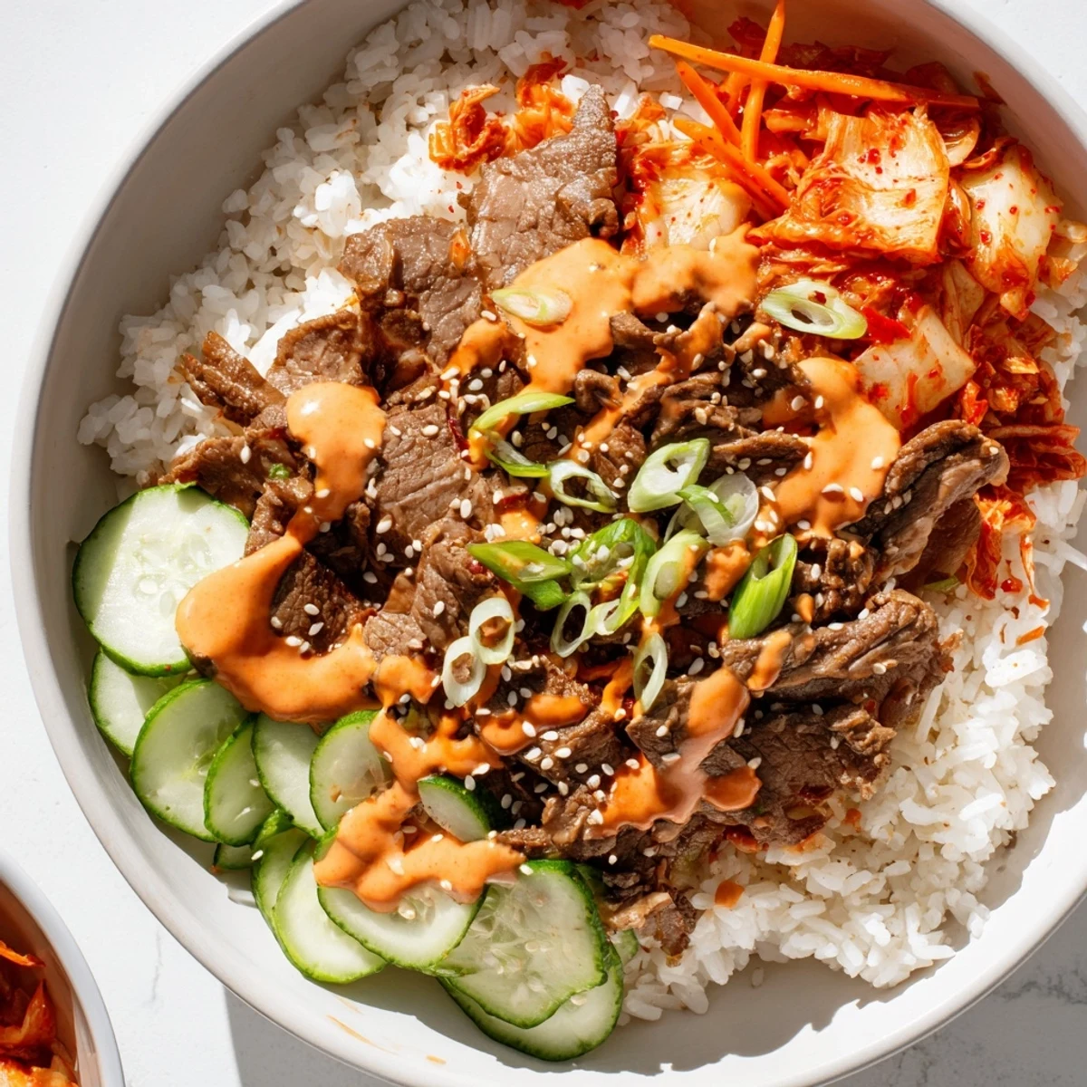 Sizzling marinated beef slices nestled beside fresh greens in Korean BBQ steak rice bowls finished with sesame seeds