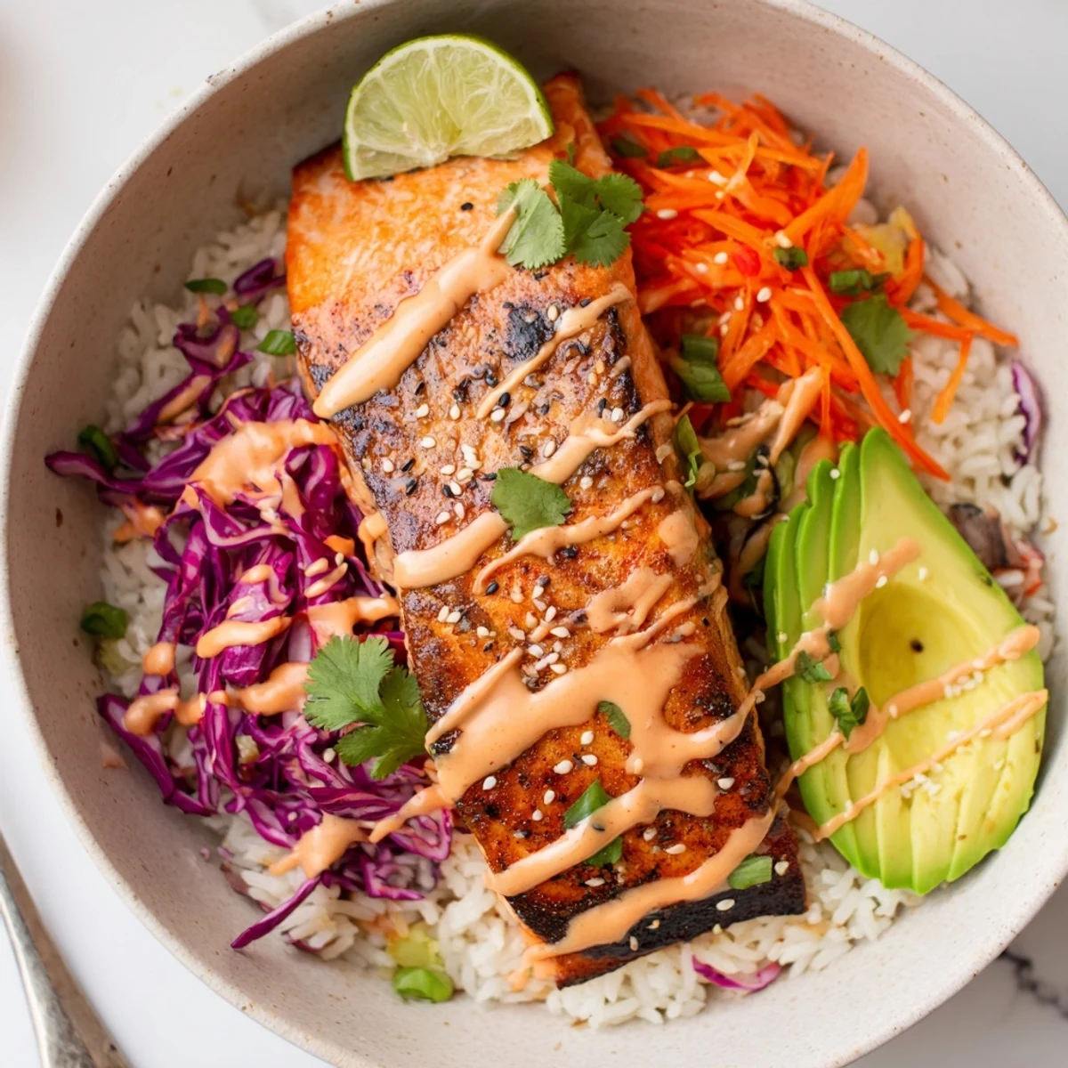 Warm Bang Bang Salmon Bowls layered with jasmine rice, crisp cabbage, avocado