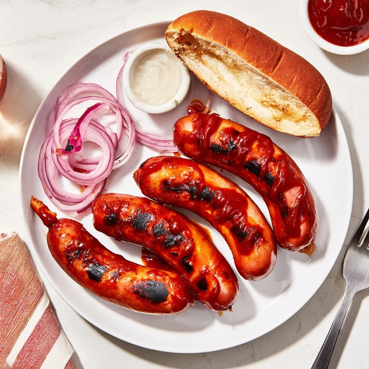 BBQ Sausage Recipe: charred, glossy links brushed with tangy sauce on grill.