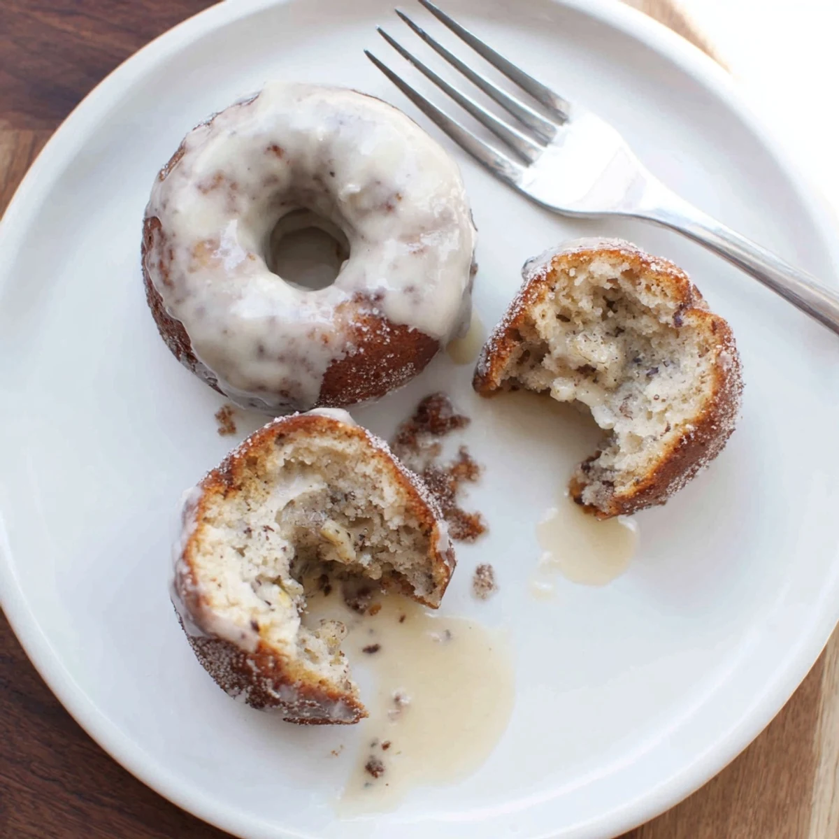 Glazed Banana Donuts piled on plate, soft crumb and cinnamon hint