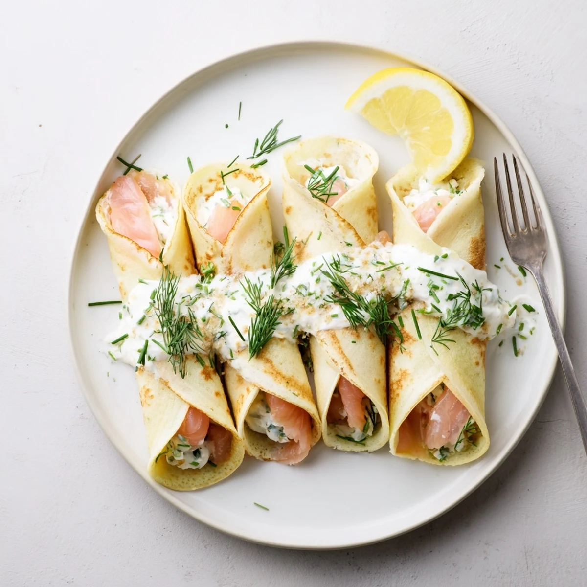 Delicate handmade crepes rolled with cream cheese filling and thinly sliced smoked salmon sprinkled with chives
