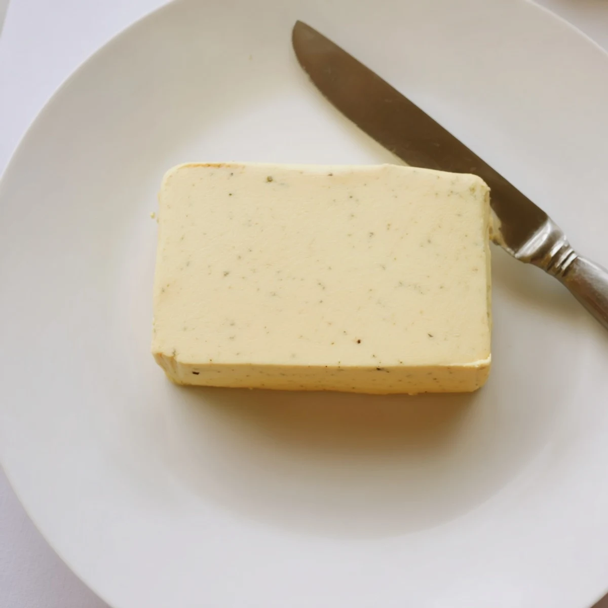 Golden vegan dairy free butter spread thickly on toasted sourdough bread slice