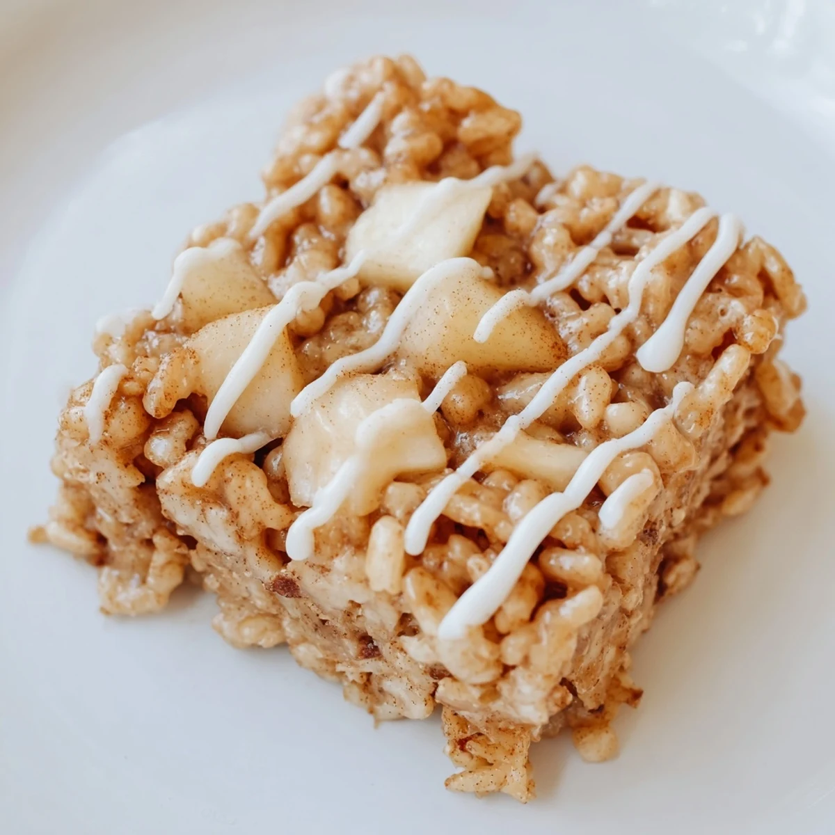 Chewy apple pie Rice Krispie bars drizzled with white chocolate and topped with diced caramelized apples