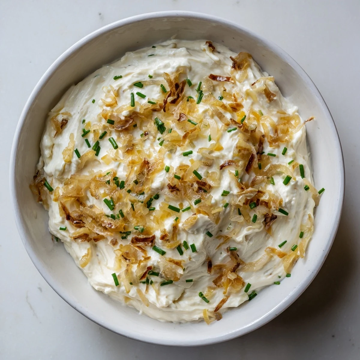 Bowl of savory French onion dip with golden brown onions served for party appetizer