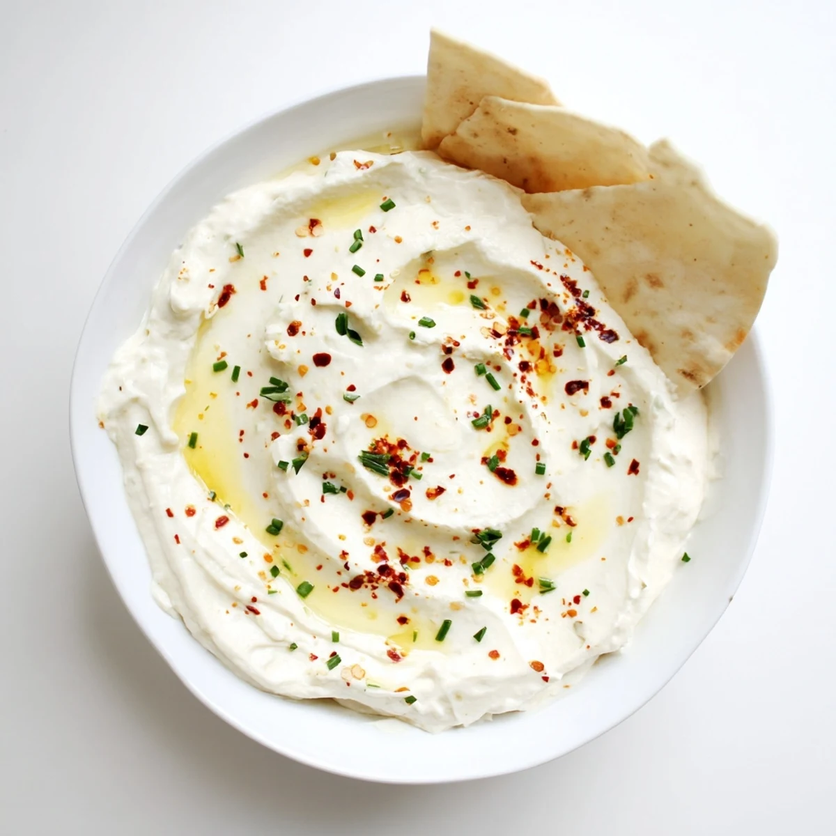 Velvety whipped feta cheese bowl with warm red pepper honey and fresh herbs