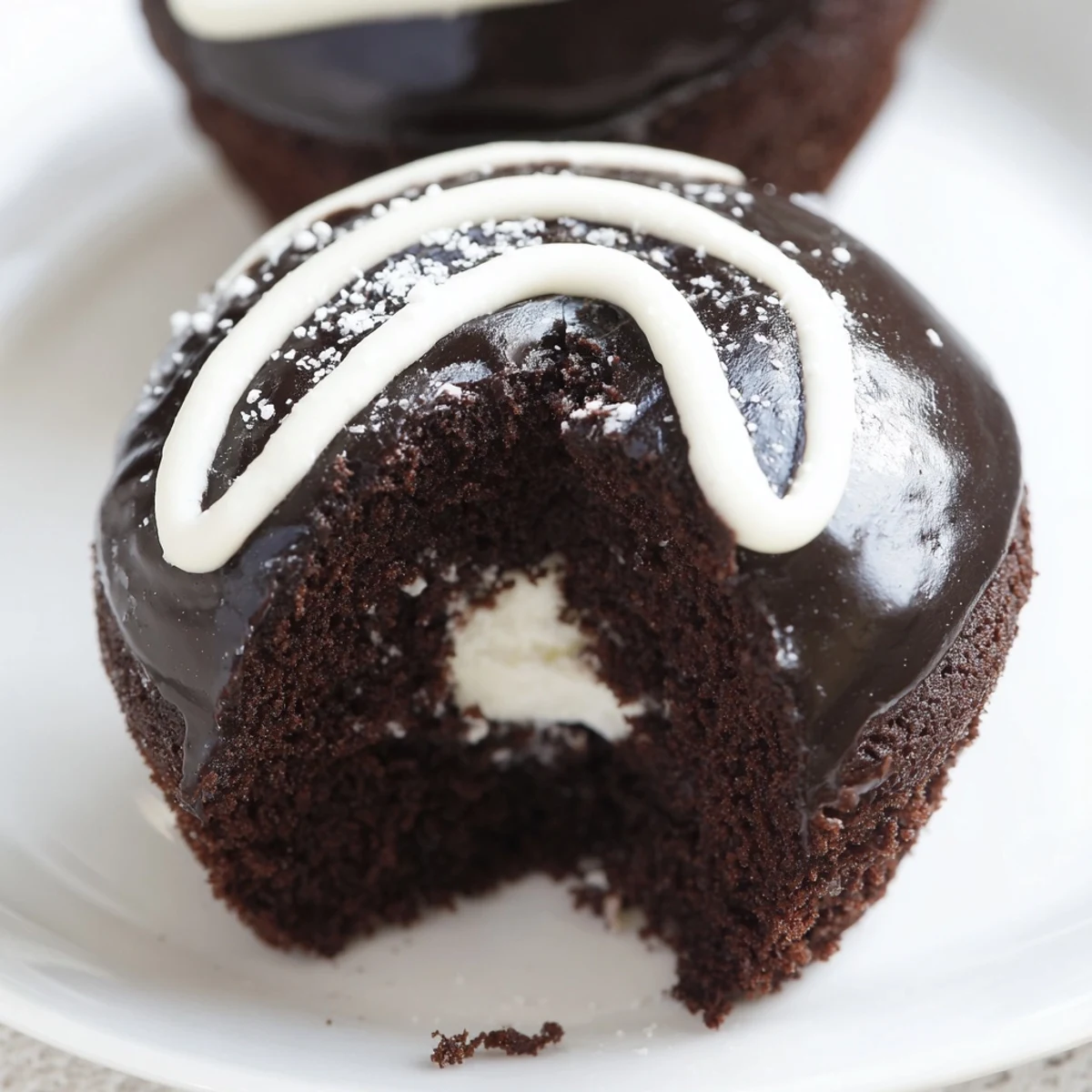 A plate of Homemade Hostess Cupcakes featuring rich chocolate glaze and signature white swirl
