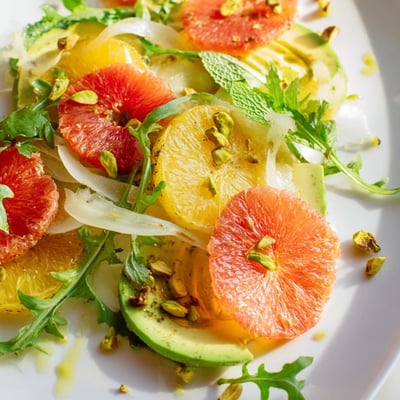 Colorful Winter Citrus Salad with Fennel and Avocado tossed with arugula, mint, and glistening olive oil dressing.